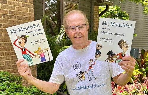 Joe Kimble holding copies of his two children's books.